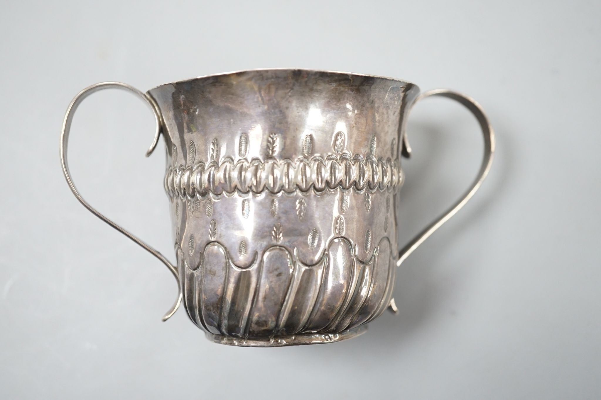 A George III embossed silver porringer, FM, London, 1766, 64mm, 79 grams.